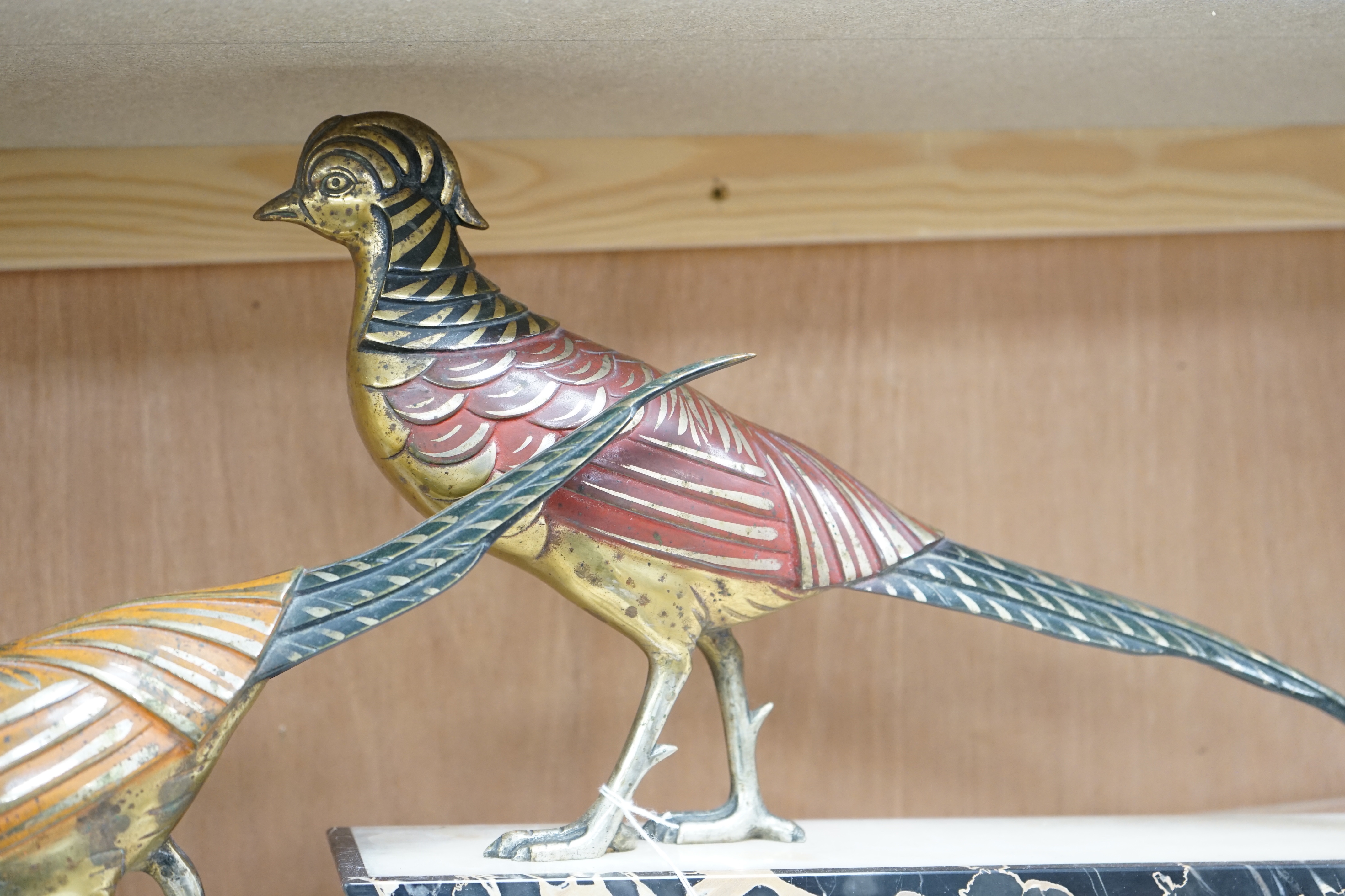 An Art Deco patinated bronze model of two pheasants on marble base, stamped ‘bronze’ and signed ‘Hugues’, 70cm long